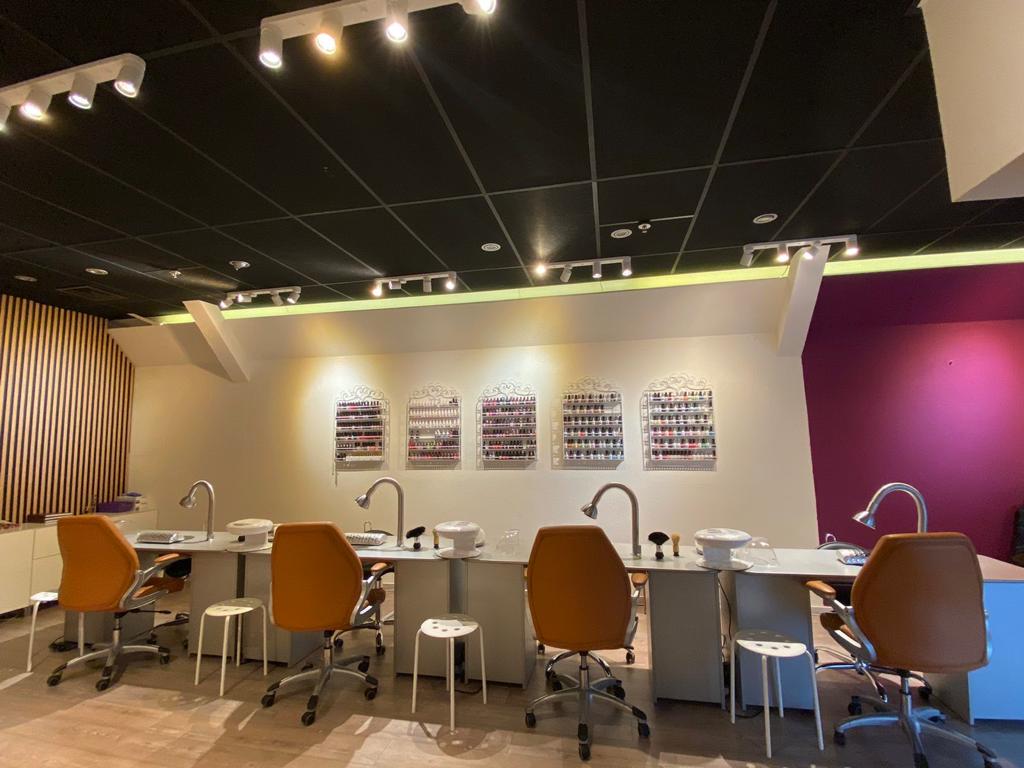 Lange manicuretafel met lakrekken en magenta muur